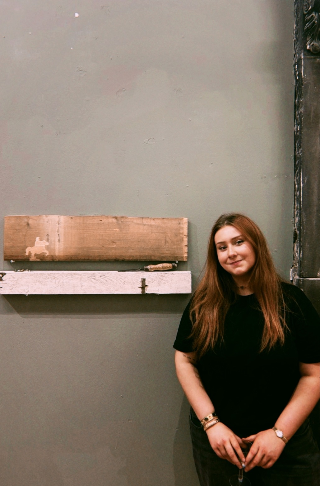 artist in front of wooden art 