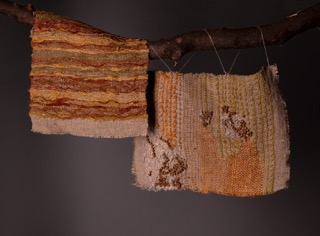 An Image of two upholstery samples hung on a branch. The samples are made from homegrown and hand-spun linen, and dyed with natural dyes.