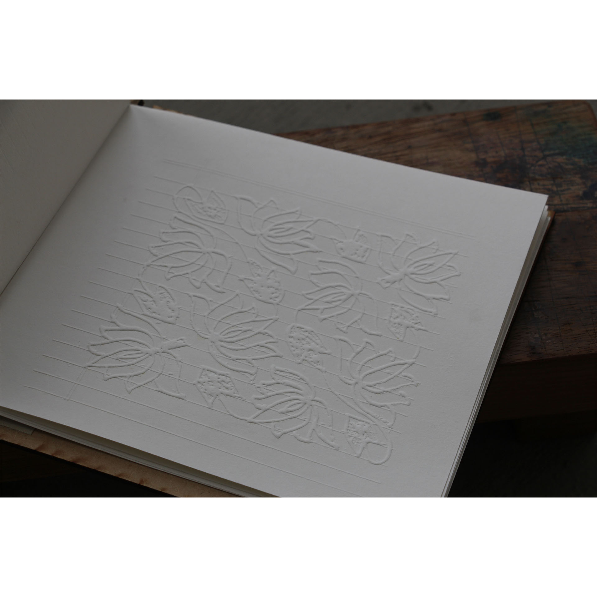 Open book displaying an embossed print.