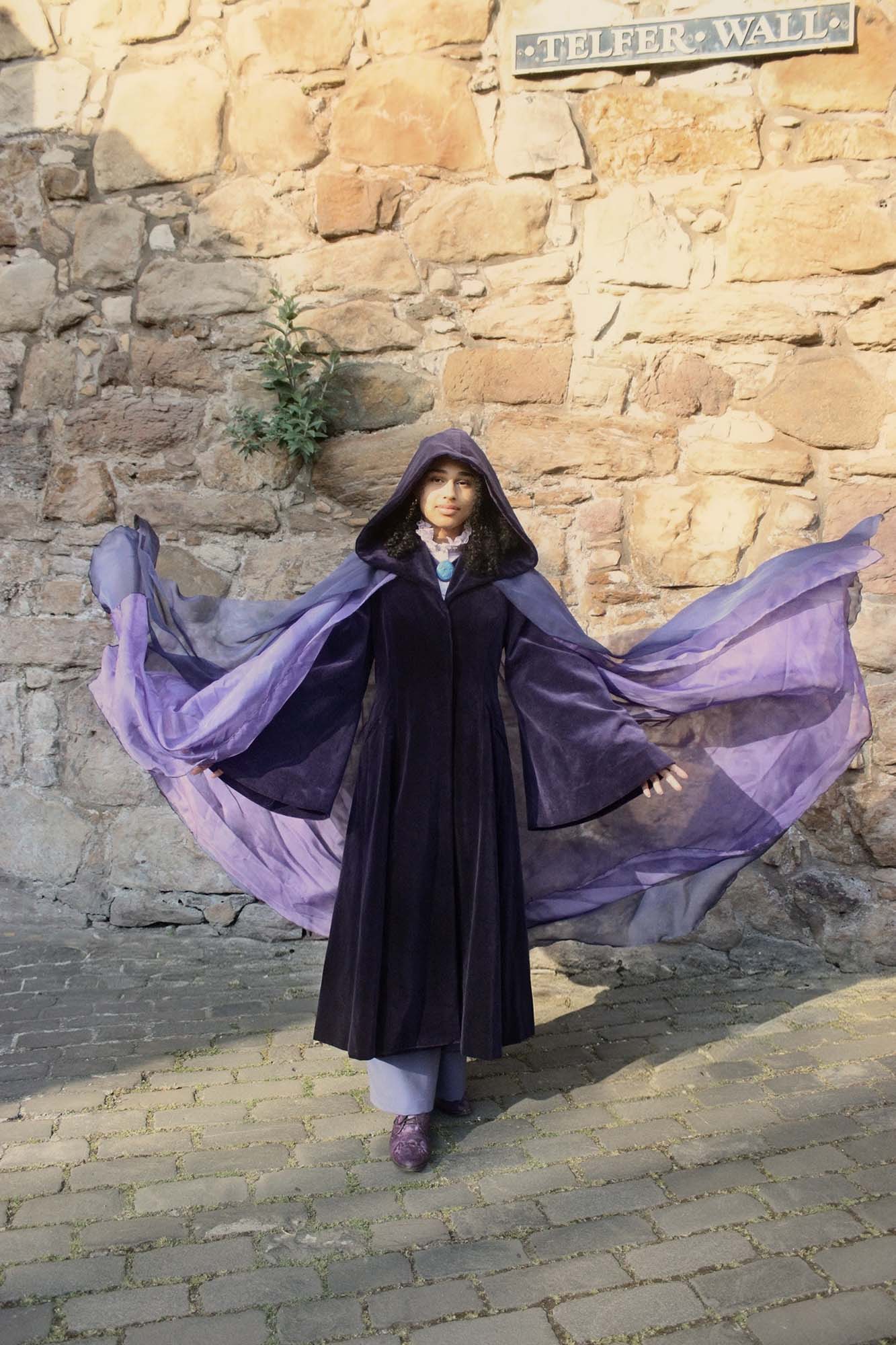 All purple outfit on female model with cloak 