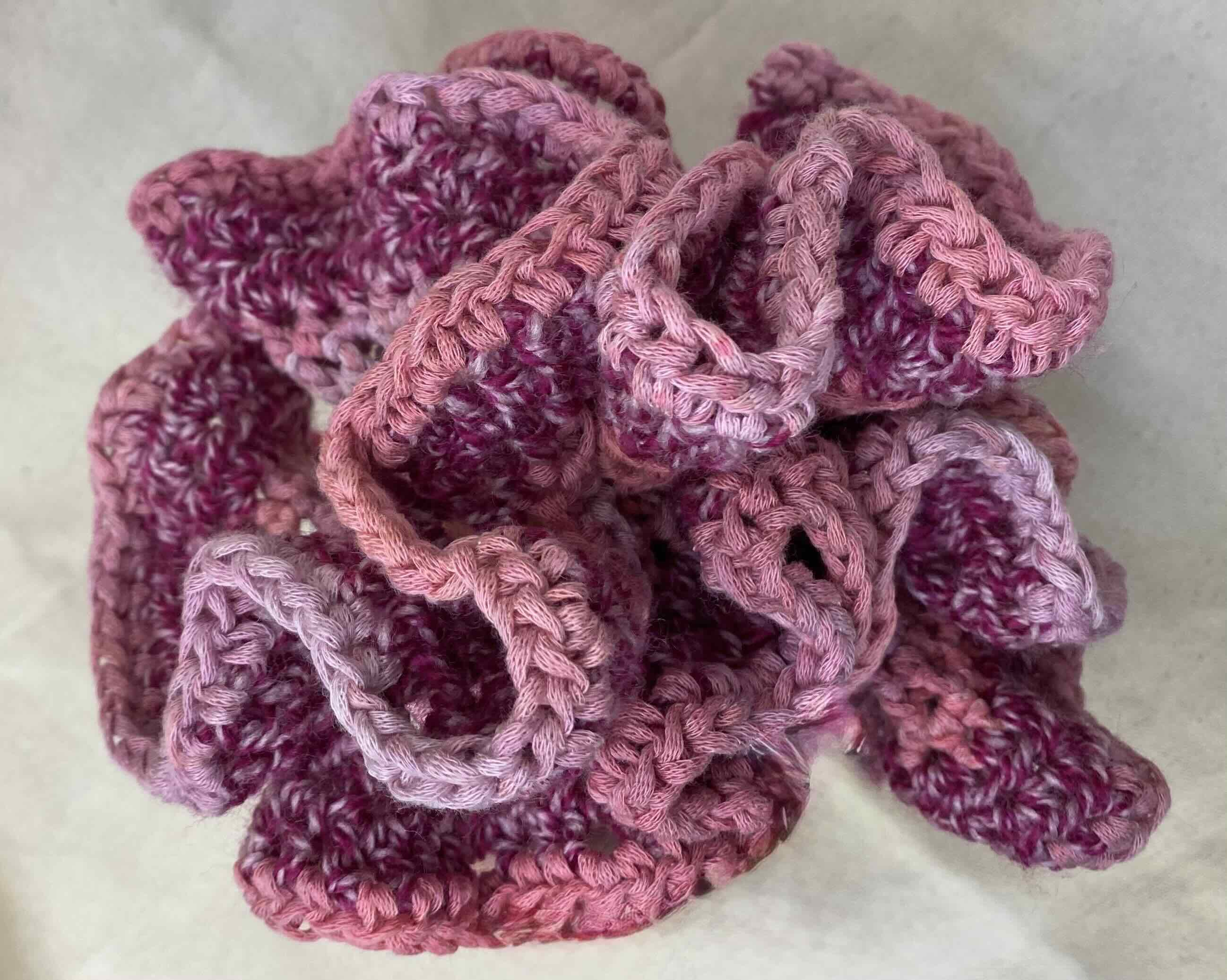 A bundle of crochetted fabric with a white background