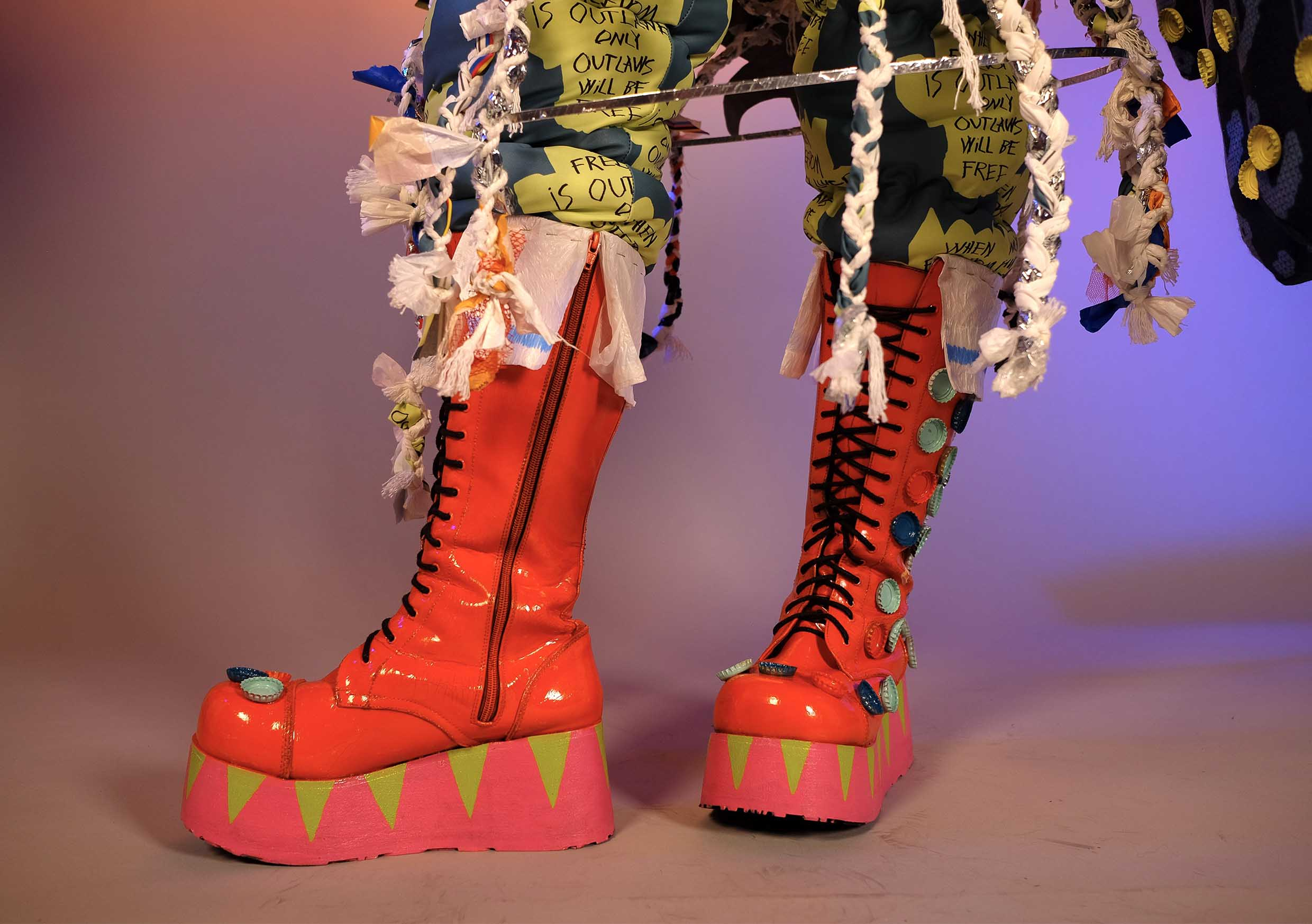 Close up of orange boots with spray-painted bottle caps.