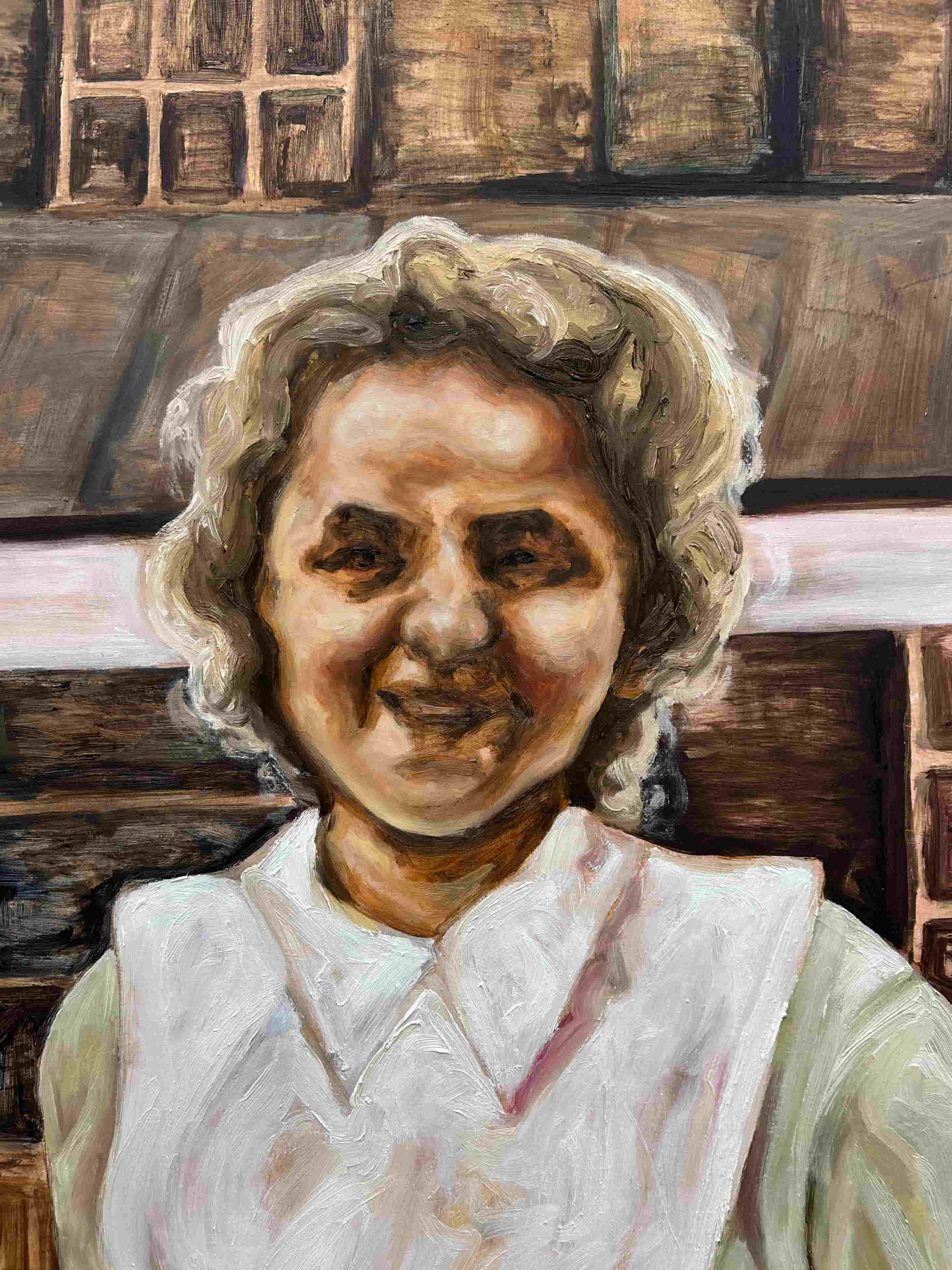 A nurse in a green uniform stands smiling at the viewer.