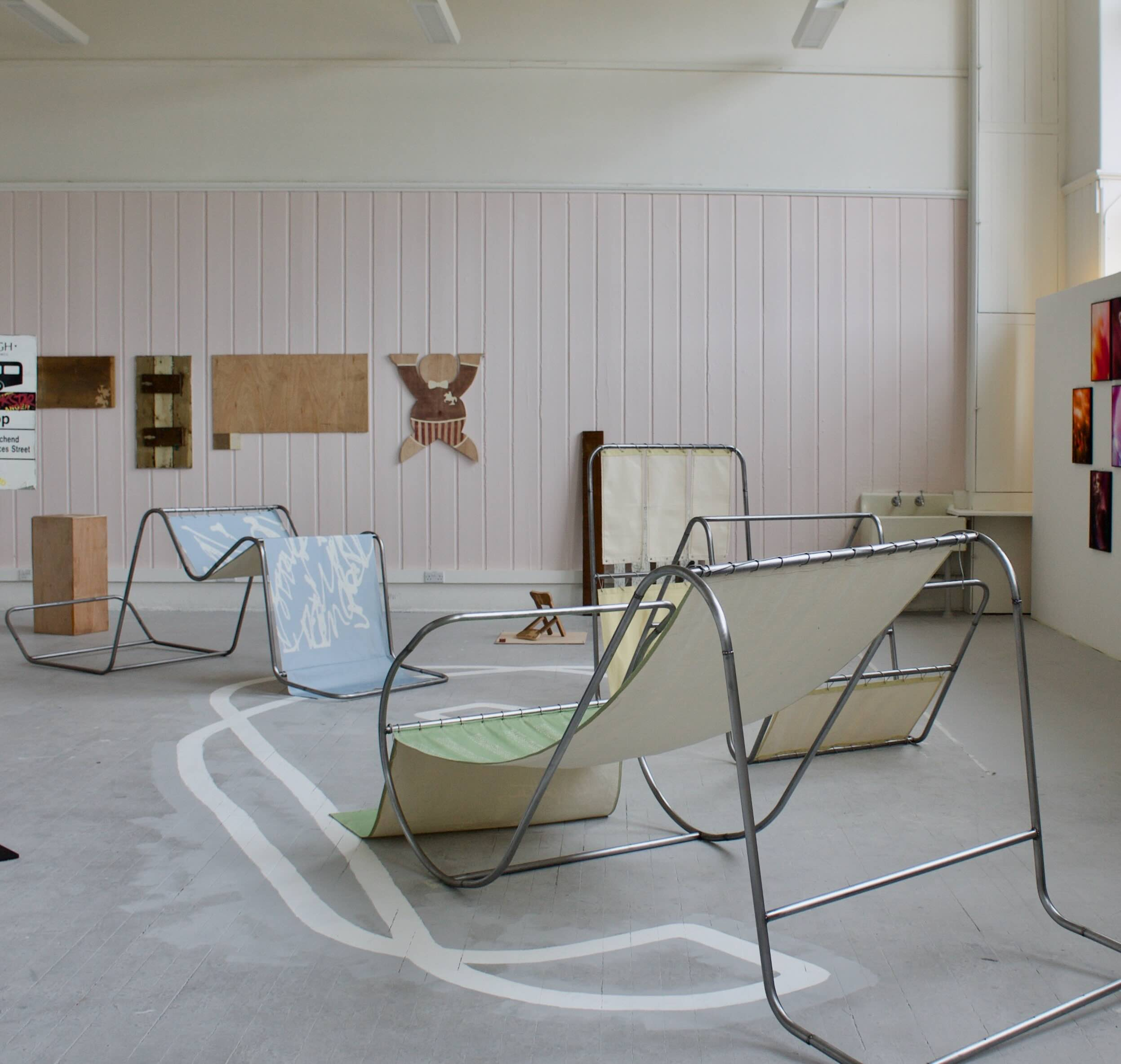 Pictured: installation view of three large-scale metal letter frames draped with fabric, fixed with para-cord.