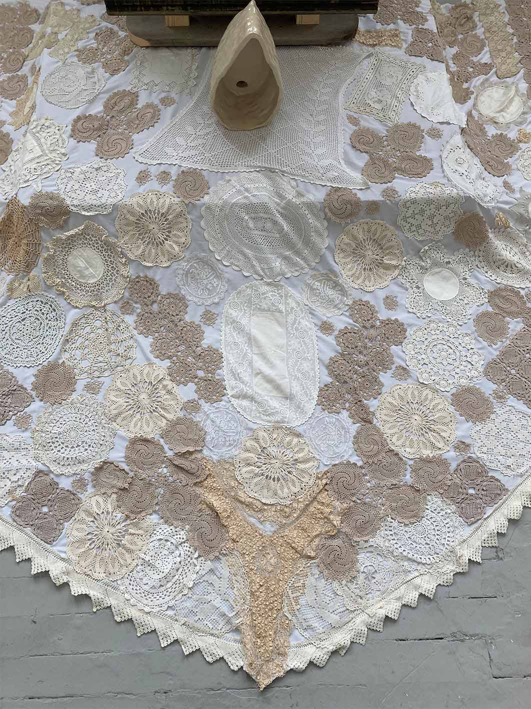 Image of crochet rug installed under ceramic and wood sculpture.