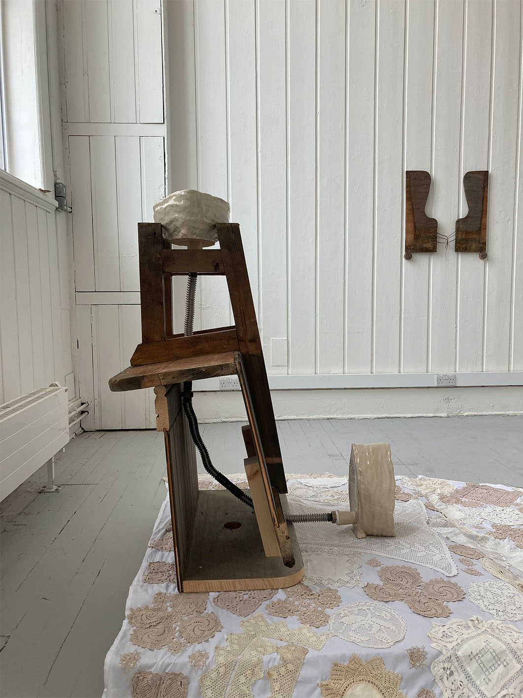 Image of sculpture made from ceramic, wood, metal piping, and textiles.