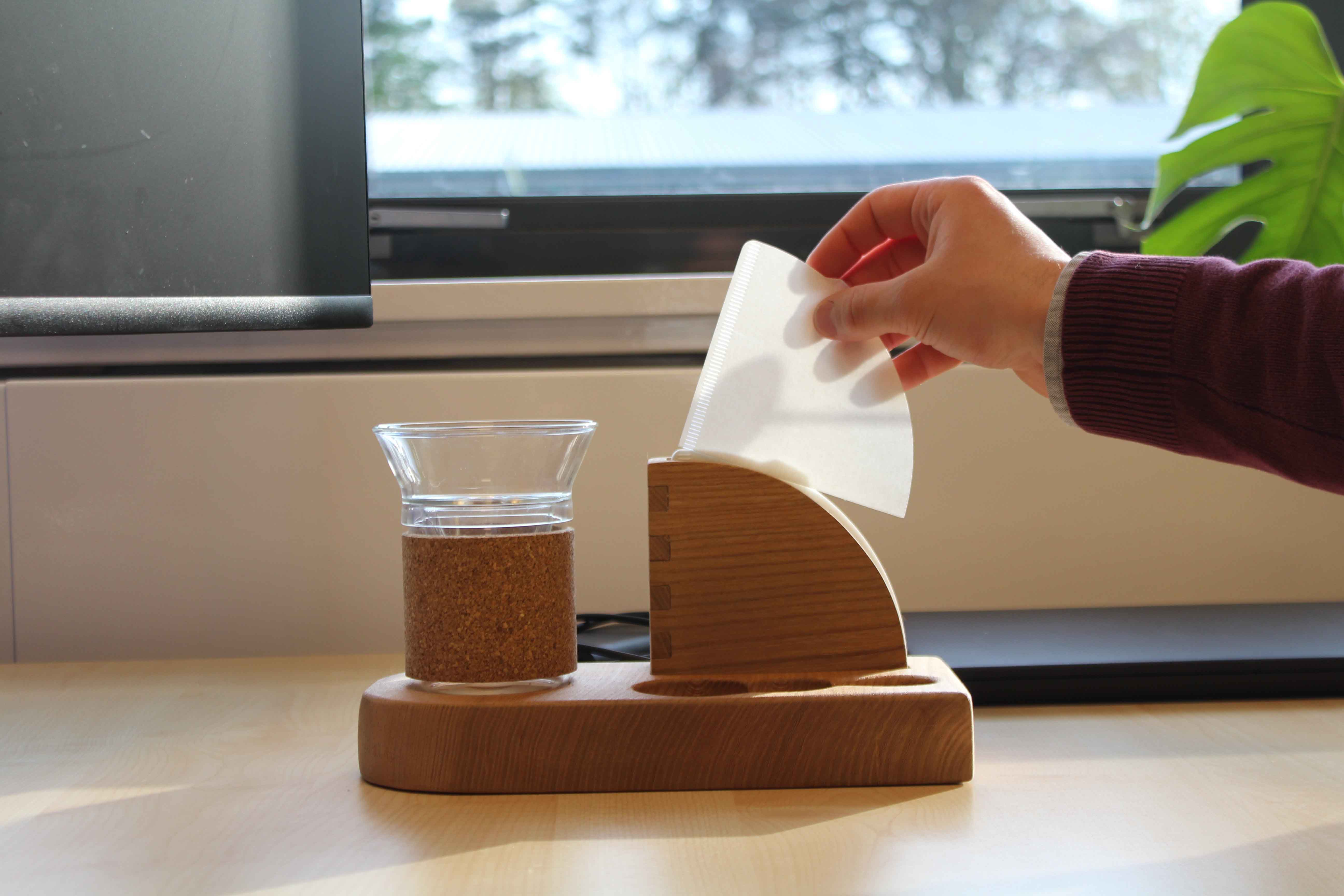 User picking up filter paper out of the filter paper holder part of the product. 