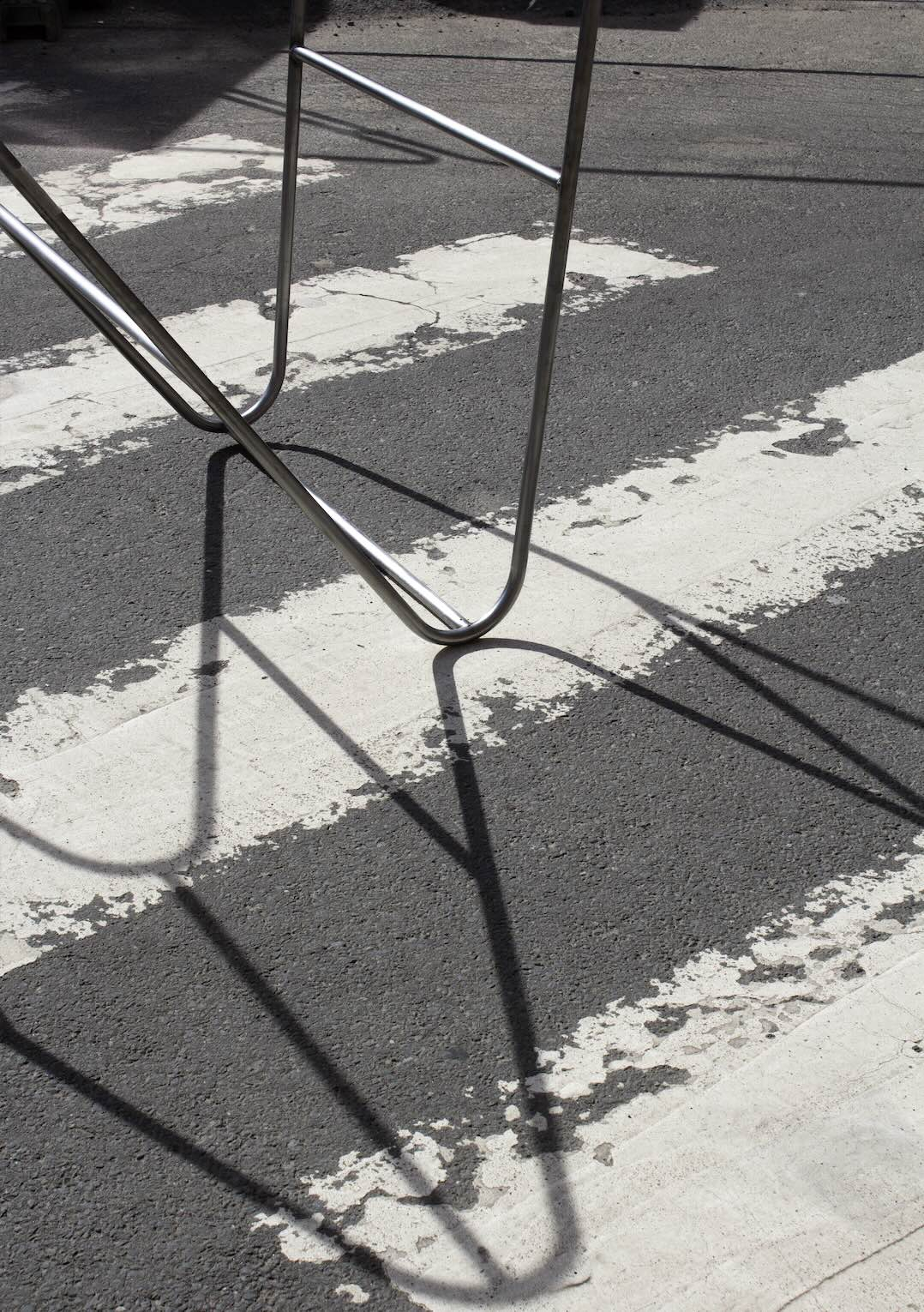 Pictured: the shadows cast by a section of the 'n frame', the shadows fall on the white painted lines of a zebra crossing.